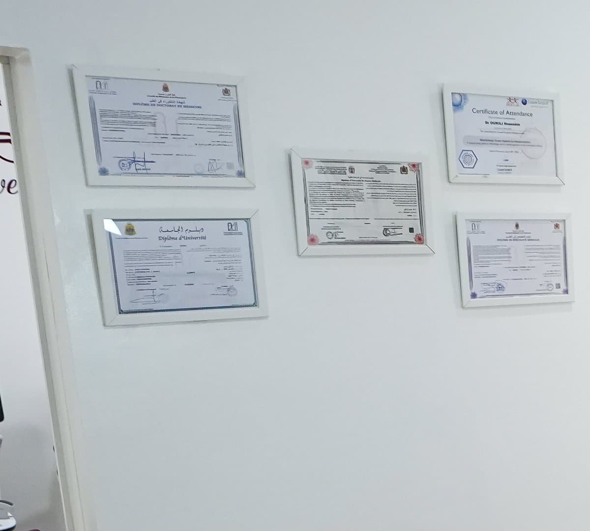 Les diplômes du praticien encadrés au mur du bureau
